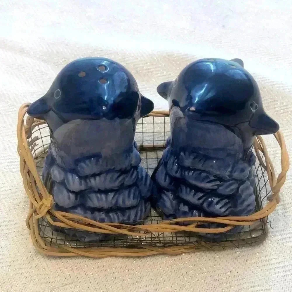 Dolphin salt & pepper shakers in wire and wood basket.